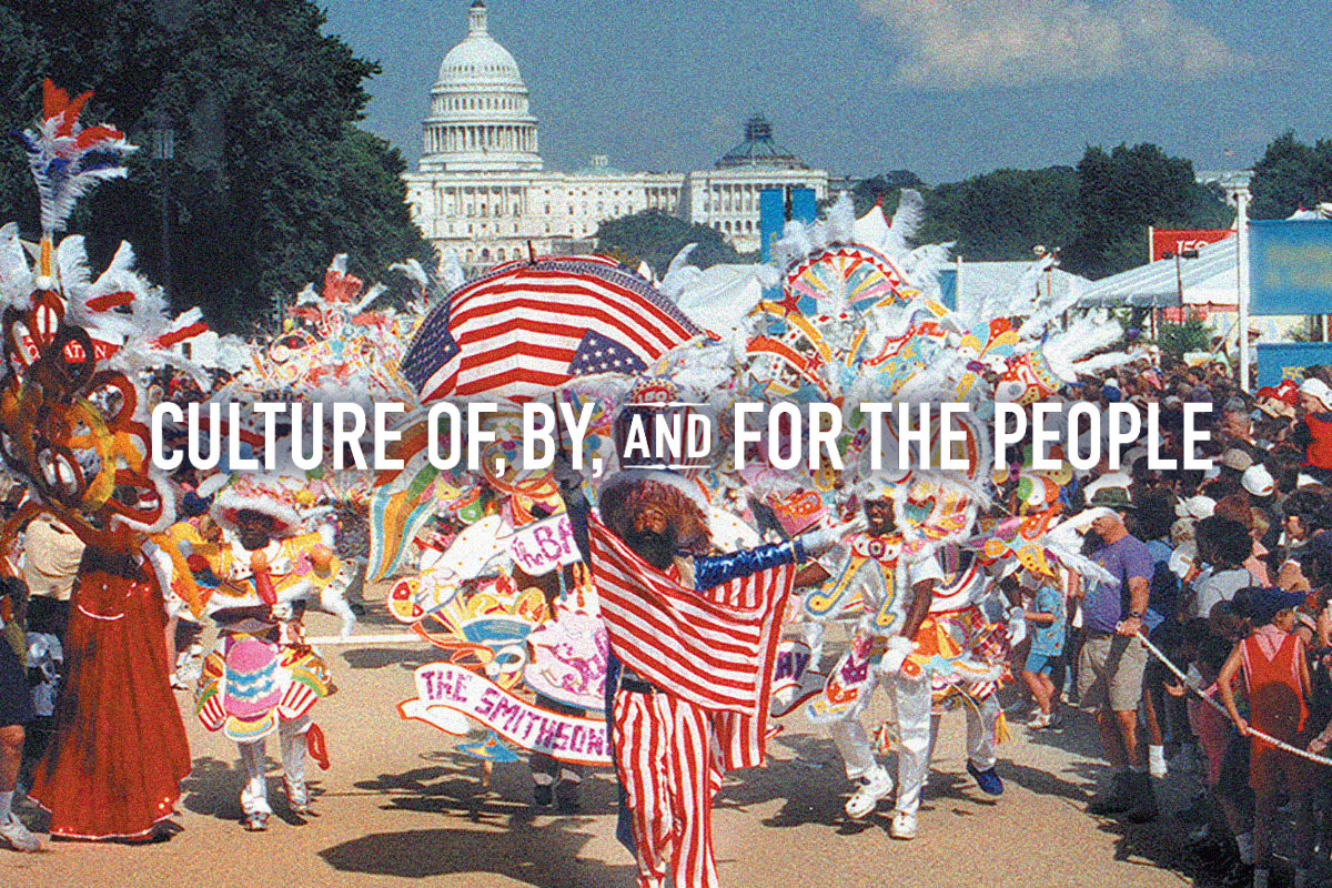 A vibrant parade on the National Mall with participants in colorful costumes, carrying flags and banners, in front of the United States Capitol building. Text is overlaid on the image that reads: 