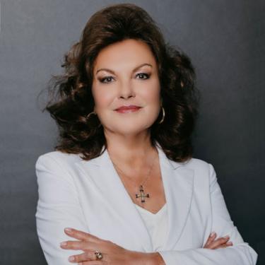 Headshot of Heidi Kuhn wearing white top, arms crossed.