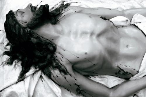 Black and white detail photo of the statue of Jesus, shirtless, emaciated, and bloodied.