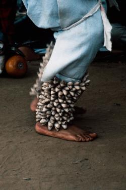 Close-up on a pair of bare feet wearing jingle bell anklets.