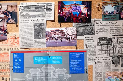 Cork bulletin board containing newspaper clippings, photographs of D.C. Chinatown, and a blueprint for the Friendship Archway.