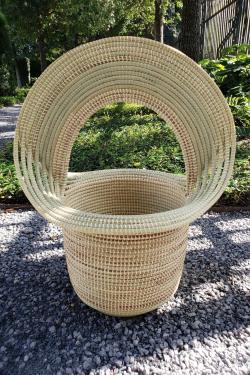 A frontal view of a finished sweetgrass basket-inspired sculpture outside.