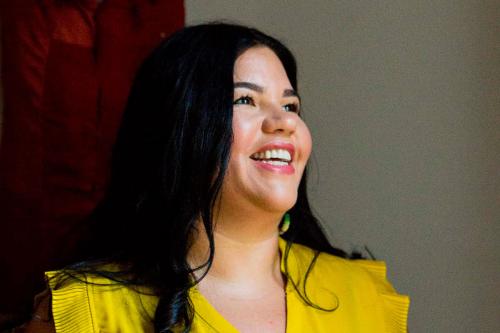 Portrait of a woman with long dark hair, smiling.