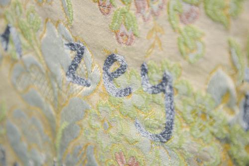 Close-up on the cloth with embroidered characters reading ZEY in silver.