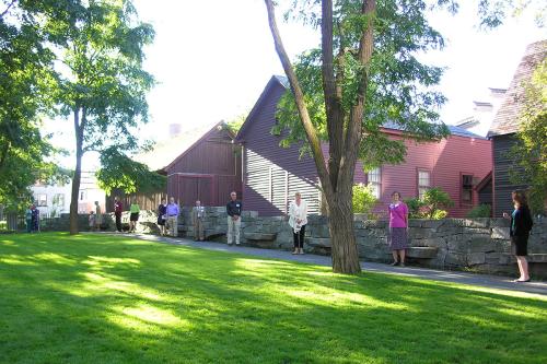 One side of the stone wall memorial, with a person standing at each stone bench  jutting out.