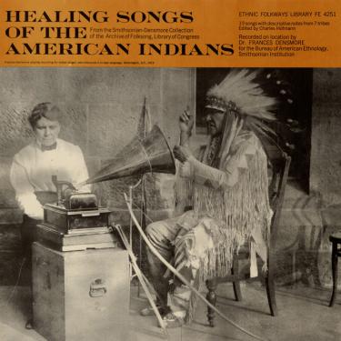 Cover art for the album “Healing Songs of the American Indians” with a black-and-white photograph of a Native American man in full regalia sitting in front of a phonograph.