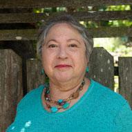 Judy Kunofsky headshot, wearing turquoise shirt and jewelry.