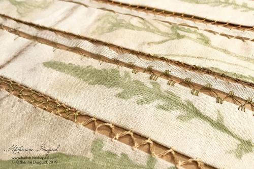 Closeup on textile art, strips of fabric crocheted together and printed with green leaves and floral shapes.