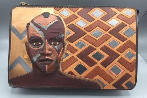 A clutch depicting a figure depicted from the shoulders up with a diamond pattern made of brown, silver and black.
