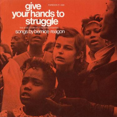 Album cover for Give Your Hands to Struggle - The Evolution of a Freedom Fighter - Songs by Bernice Reagon, with a photo of a diverse crowd of protestors singing, tinted red.