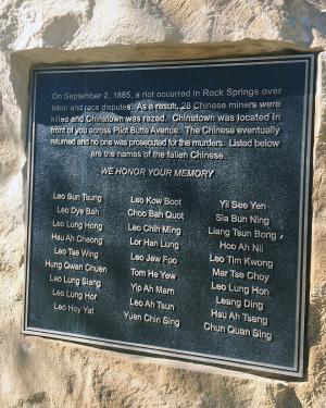Bronze plaque set in stone. It reads: On September 2, 1885, a riot occurred in Rock Springs over labor and race disputes. As a result, 28 Chinese miners were killed and Chinatown was razed. Chinatown was located in front of you across Pilot Butter Avenue.