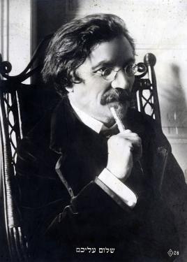 Black-and-white portrait of a man with a mustache and glasses, holding the end of pen to his lip.
