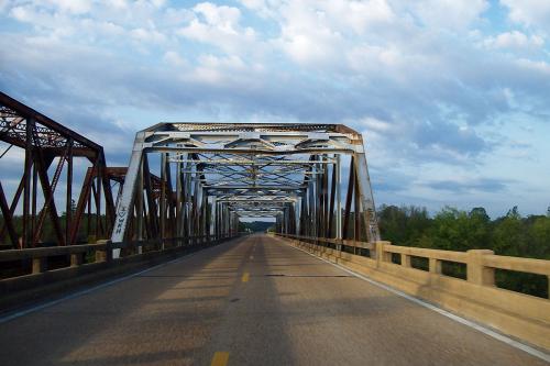 An old steel bridge along a highway.
