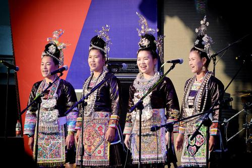 Four women singers in ornate dress performing on stage.
