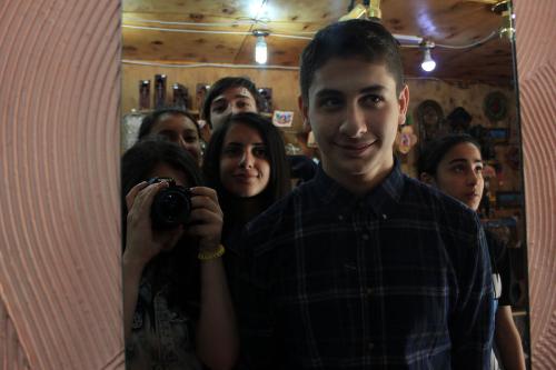 Teens pose together, framed in a mirror. Alen, in front, is smiling.