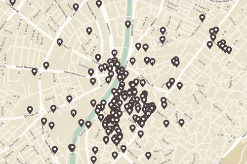 Google map of a city in neutral brown colors, with a river running through the middle, and dozens of brown pinpoints to click for information.