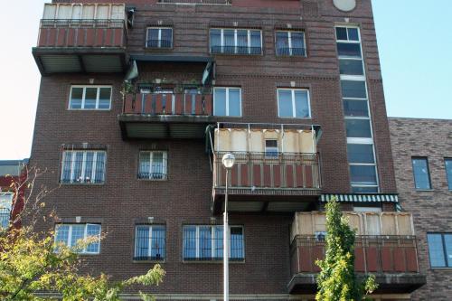 A five-story apartment building with four temporary enclosed structures protruding from the front, one on each upper story, arranged in a diagonal line.