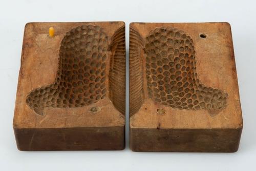 Two sides of a wooden textured mold to form a lamb shape displayed against a white background.