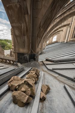 Jagged pieces of stone lie beneath a stone buttress of the National Cathedral.