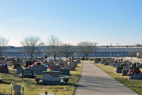 Crowds of people in formalwear outdoors in a cemetery.  Black-and-white photo.