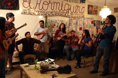 A group of people practice jarana together, all smiling. César is leading the group on the right.