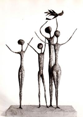 A sculpture of four standing figures with elongated bodies and outstretched arms on a square base.