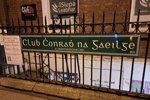 The exterior of a nightclub, with a green sign that reads Club Chonradh na Gaeilge.