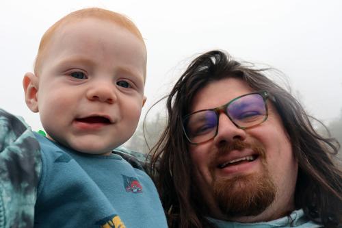 A man and baby smile.