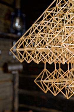 Closeup on the mobile in the previous photo, with octahedron shapes hanging from the main pyramid shape.
