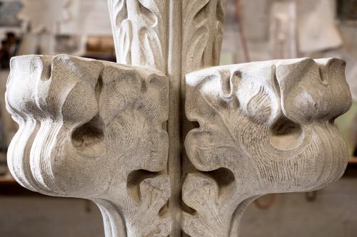 Close-up of the finished stone piece, showing a veined leaf pattern curving upward to the sky. This close, you can see the fine textured lines of the chisel.
