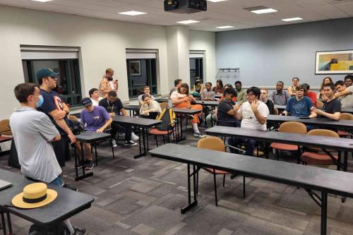 Steveral students meet in a classroom, sitting at rows of desks.