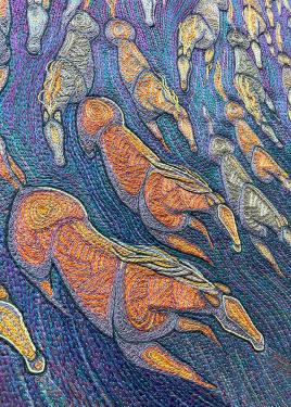 Close-up on the embroidery of the horses, showing intricate stitches in blue and orange.