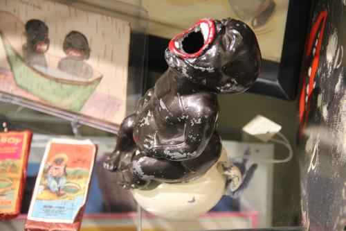 A figurine of a naked, chubby Black caricature with bright red lips and its mouth wide open for use as an ashtray.
