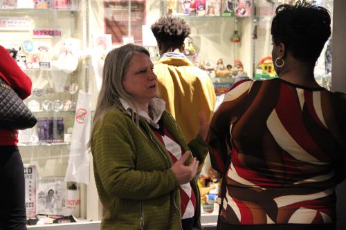 A museum staffer (who is white) talks with a visitor (who is Black).