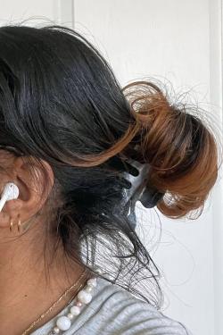 The side of the back of a woman's head, her face out of frame.