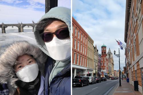 Two photos side by side: a woman and man in winter coats and white face masks pose with a frozen river and bridge in the background; view down a street of old brick buildings.