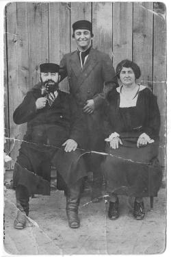 Old black-and-white photo of parents and son.