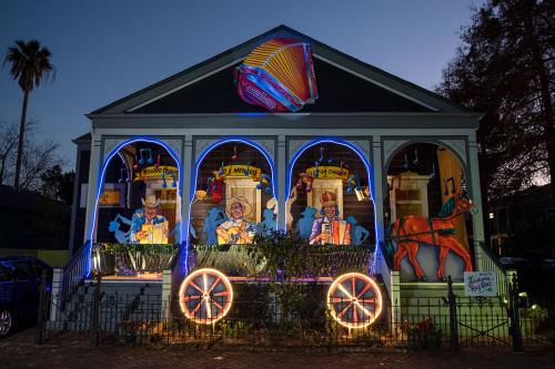 After dark, a porch with four arches decorated to look like a wagon, pulled by a two-dimensional horse in the stairway entrance, and three figures playing instruments under the arches. A giant lit-up accordion sculpture hanging at the apex of the A-frame 