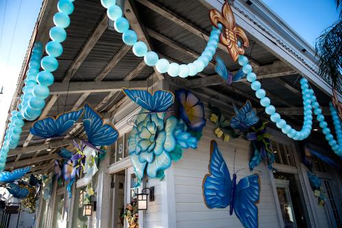 Exterior of a house decorated with giant blue butterflies and blue pearl-like streamers.