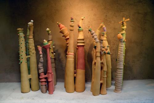Clay sculpture of several cylindrical shapes in earthen tones.