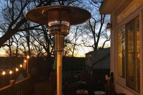 Back porch with heat lamp and string of lights at dusk.