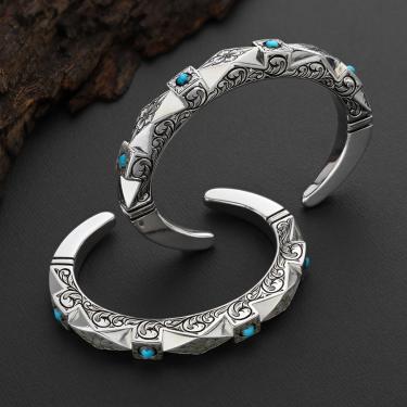 Two narrow silver bracelets engraved with geometric designs and set with small round pieces of turquoise.
