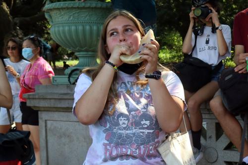 A young person plays a shofar (horn) at a rally.