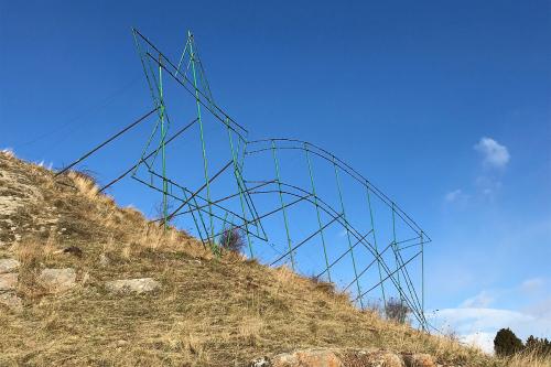Metal scaffolding in the shape of a giant shooting star standing at the top of a hill.