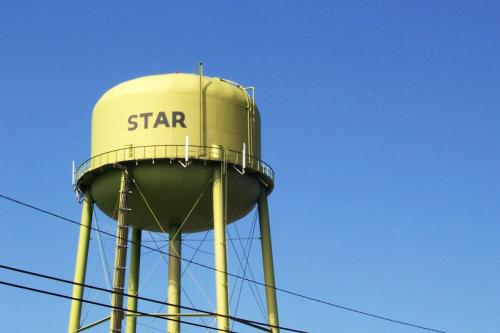 An old water tower with the town name, Star, in front of a deep blue sky.