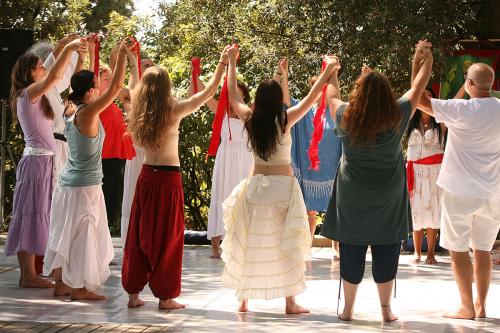 A group of mostly women join and raise their hands in a circle.