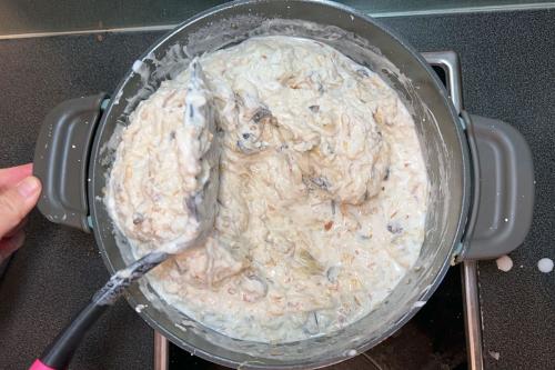 White, chunky turnip cake batter in a pot on a stove.