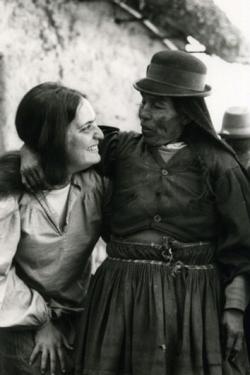 Two women embrace arm in arm.