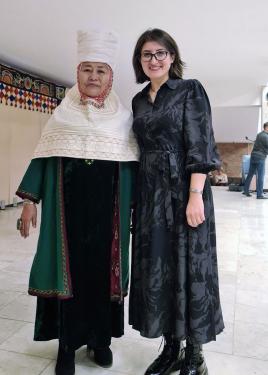 Two women pose arm in arm.