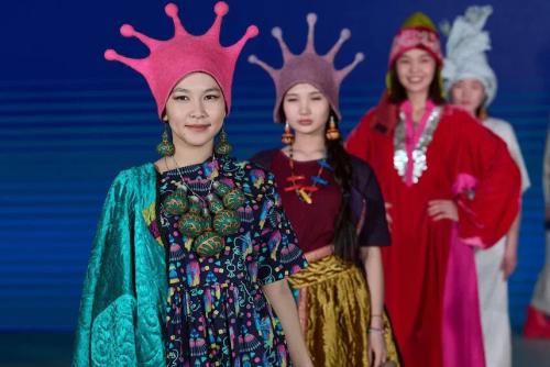Four women wearing felt hats and colorful garments.